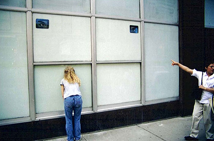 If this window could see, 2002, installation at 50 Murray Street for the Lower Manhattan Cultural Council’s Looking In exhibition, curated by Trevor Schoonmaker, two surveillance cameras, two black and white security monitors, red eyeglass template<br><br>The installation inverted the voyeuristic relationship of the viewer and the building.
